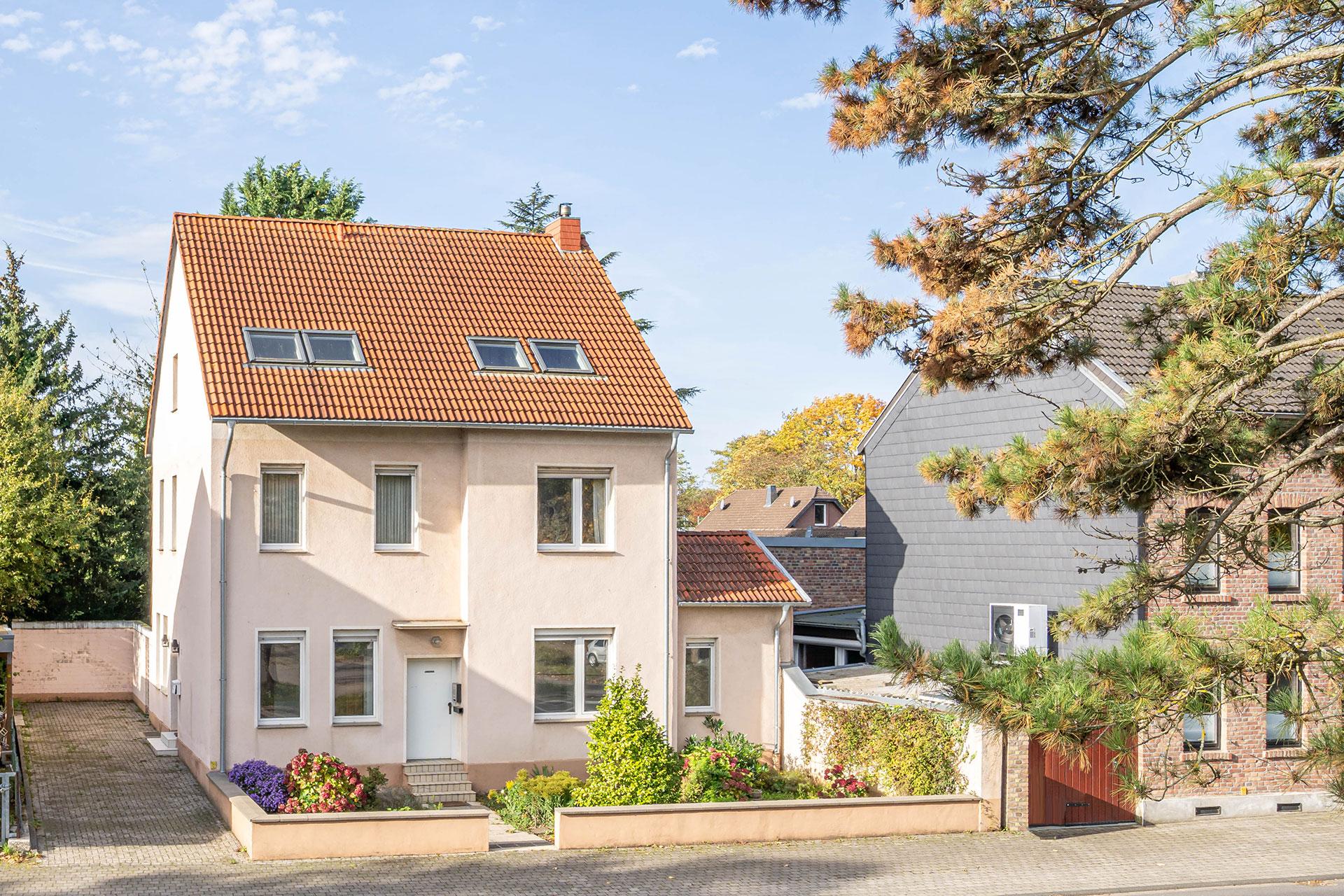 Die Vorderansicht der Immobilie mit der zufahrt und Blick auf den Eingang zur Einliegerwohnung und dem seitlichen Haupteingang zur Wohnung im Obergeschoss. Immobilie Bedburg