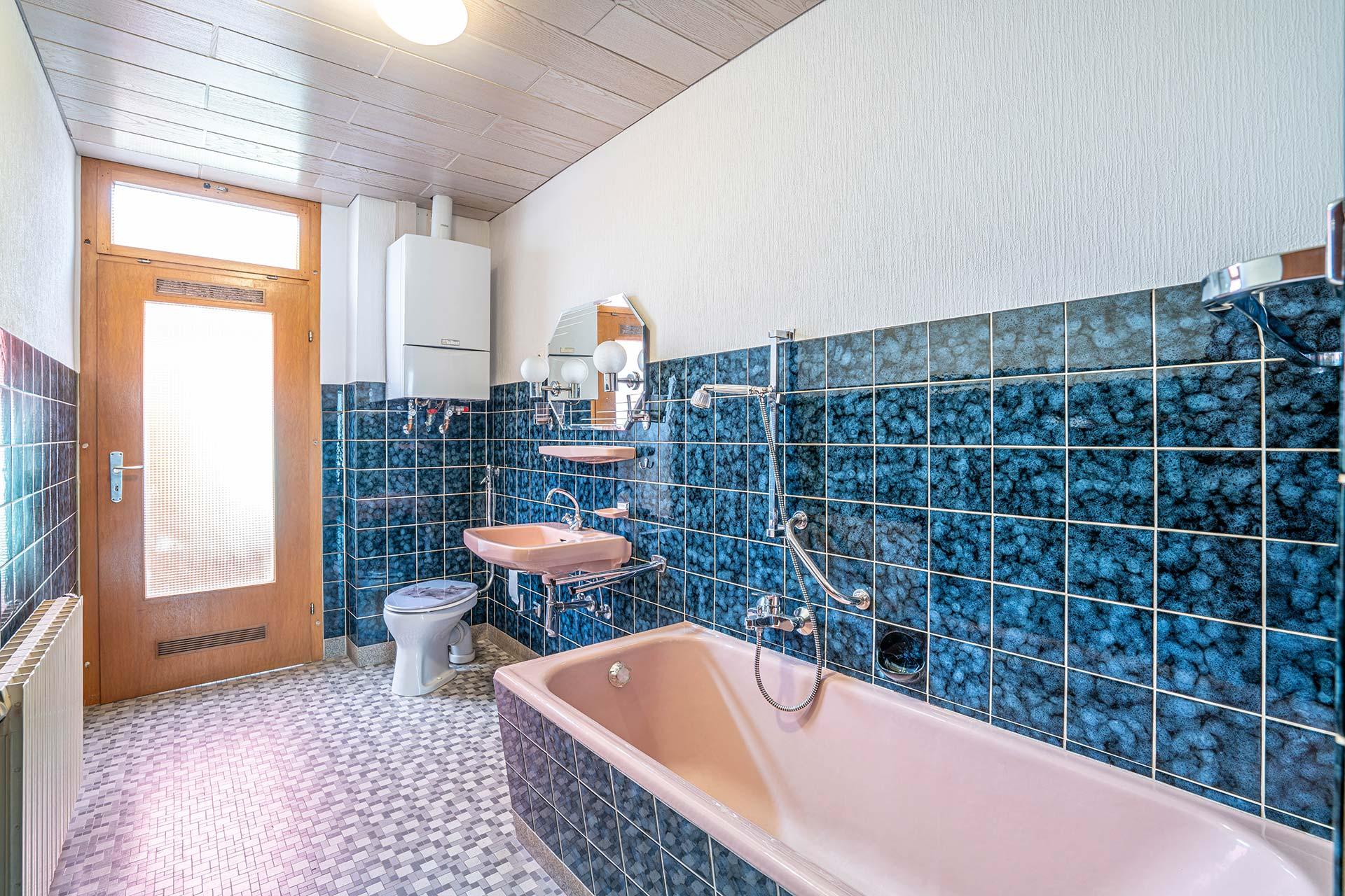 Das Wannenbad ist mit einer Tür mit Oberlicht in zur überdachten Terrasse, einer Badewanne winwm Stand-WC und einem Waschbecken ausgestattet. Auch bedinet sich die Gasheizung in diesem Raum. Reihenmittelhaus Kerpen