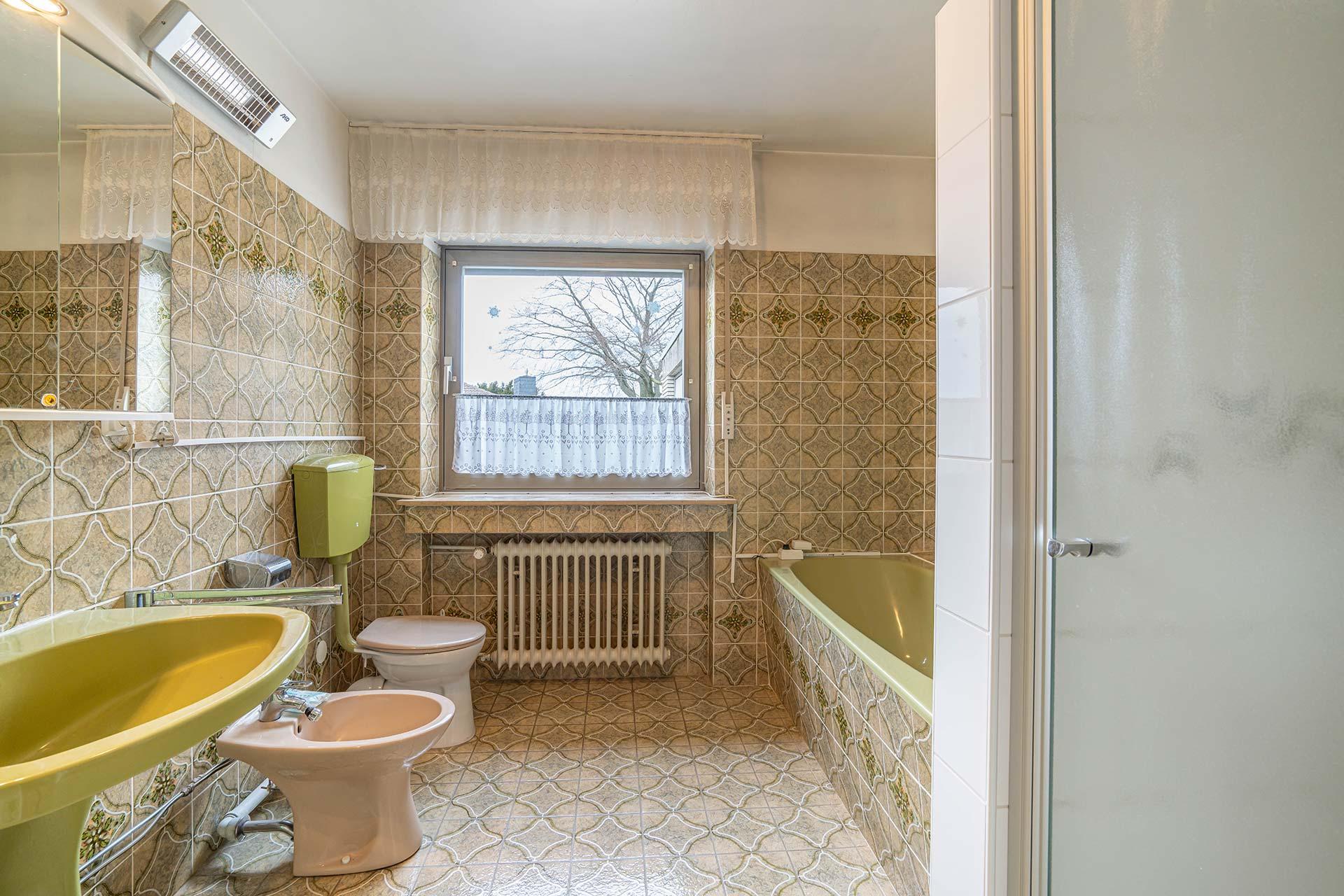 Das Badezimmer im Erdgeschoss mit Badewanne und Duche und Fenster und WC und Handwaschbecken und Bidet ausgestattat. Immobilie Bedburg