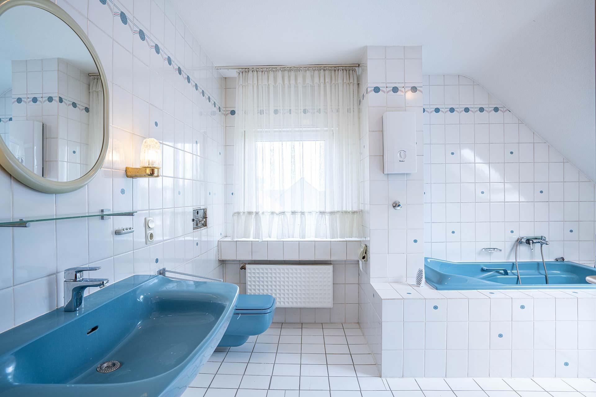 Das Tageslichtbad im Dachgeschoss ist mit einer Badewanne, einer Dusche, einem WC und einem Waschbecken ausgestattet.  Immobilie Bedburg
