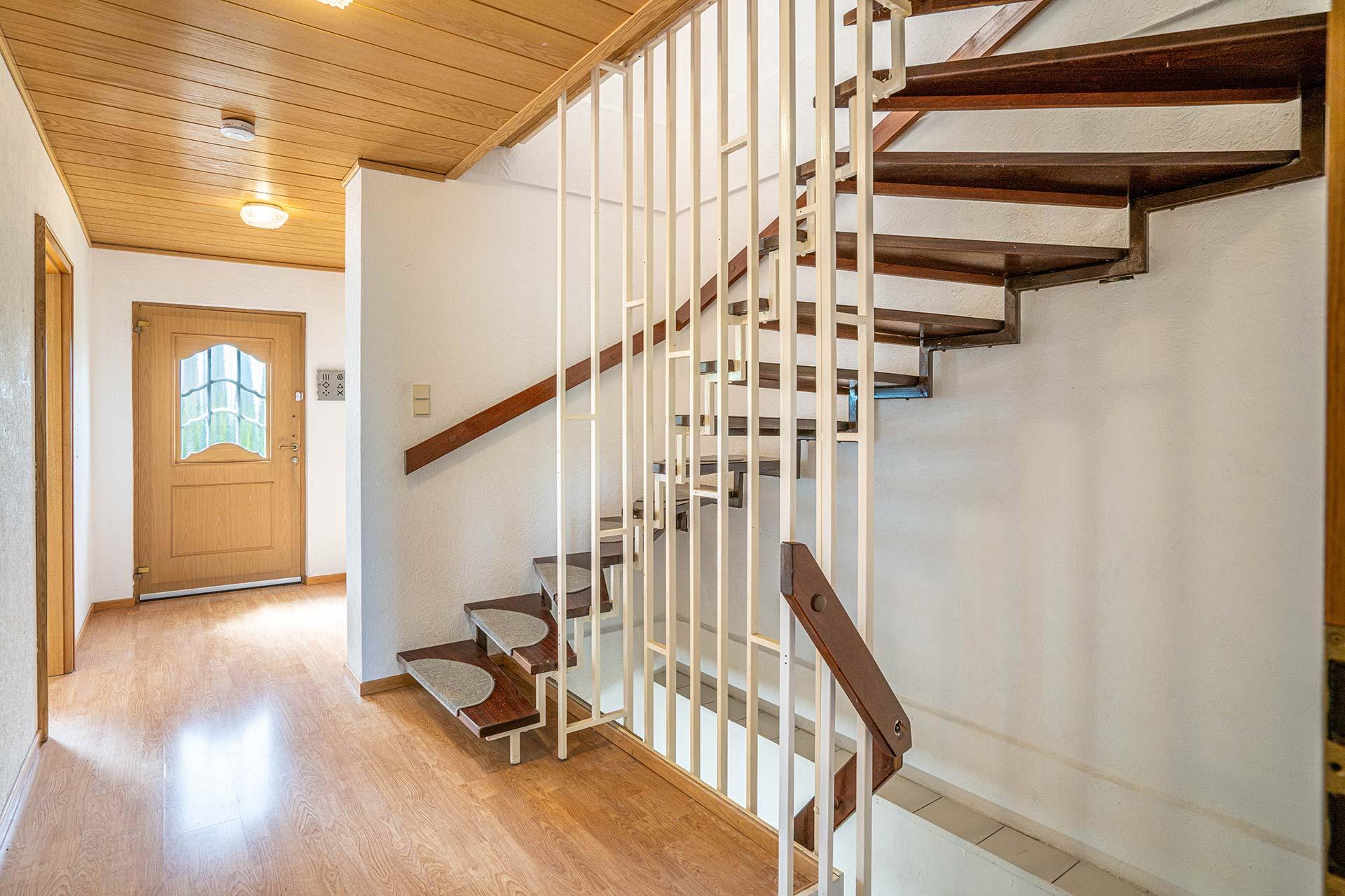 Die Eingangsdiele im Erdgeschoss aus dem Wohn- und Esszimmer fotografiert. Der Blick geht in Richtung Haustür mit zugängen zu Küche und Gäste-WC. Die Treppe führt ins Obergeschoss und in den Keller. Doppelhaushälfte Bergheim