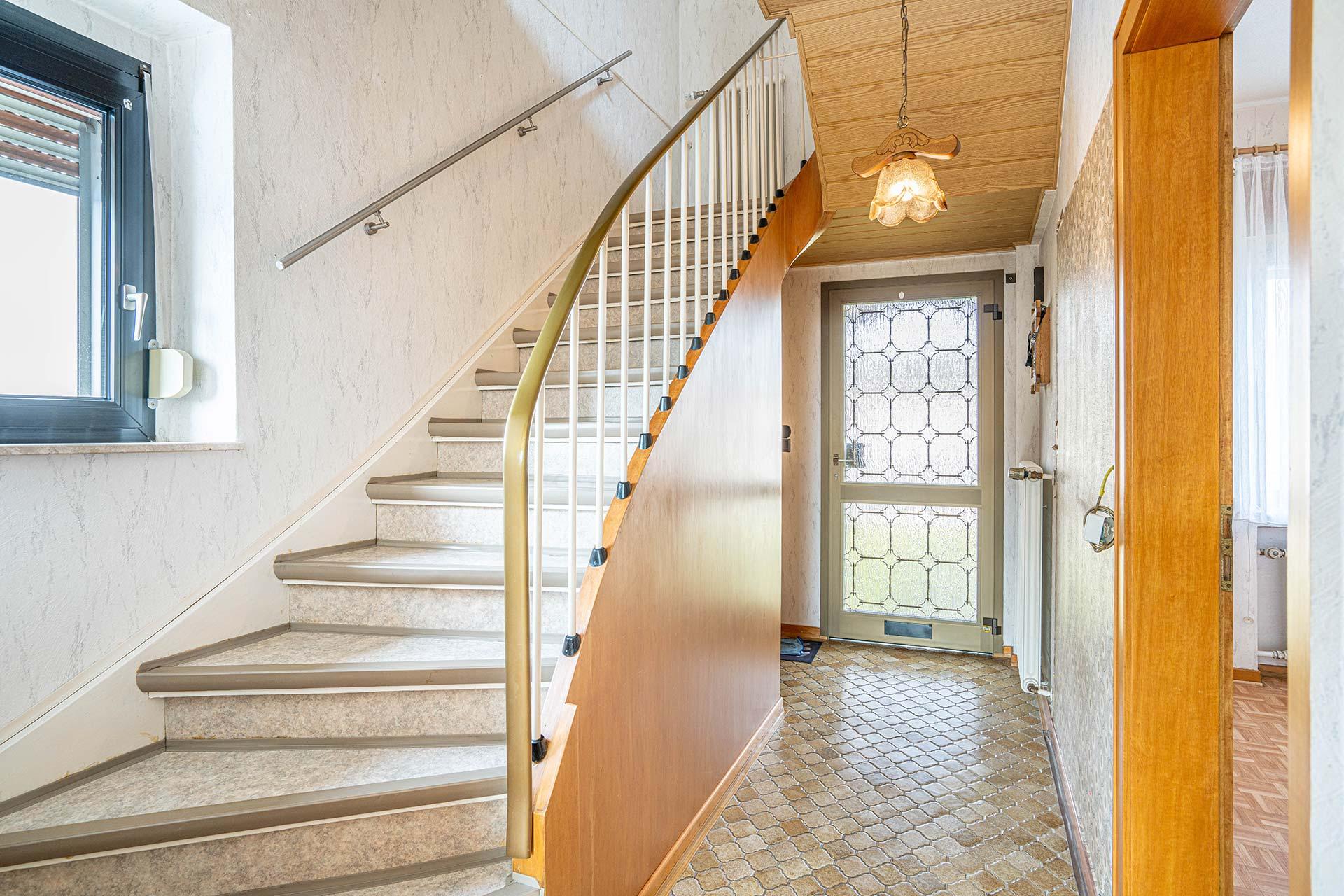 Die Eingangsdiele mit Trennenaufgang und Blick in Richtung der Haustür. Reihenmittelhaus Kerpen