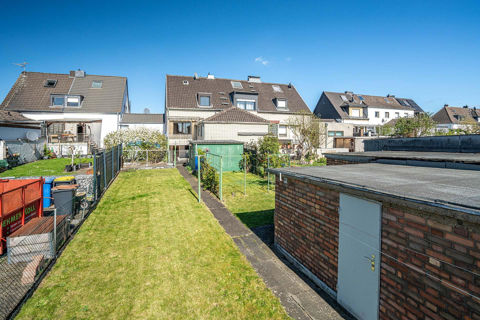 Rückansicht der Immobilie mit Blick auf dem Balkon. Vom Balkon aus führt eine Treppe in den Garten. Reihenmittelhaus Kerpen