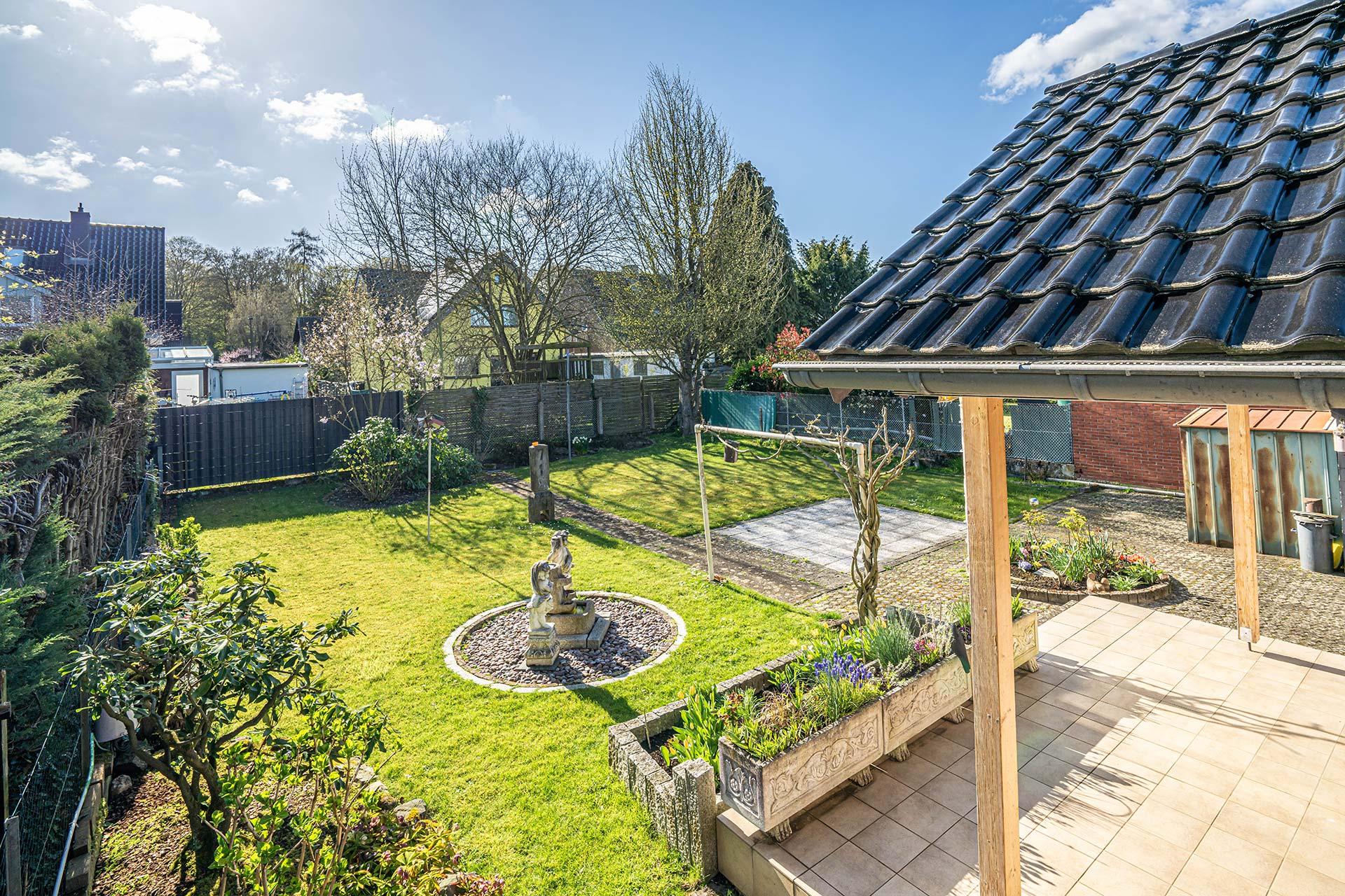 Neben der Terrasse stehend schaut man in den Garten. Bungalow Kerpen