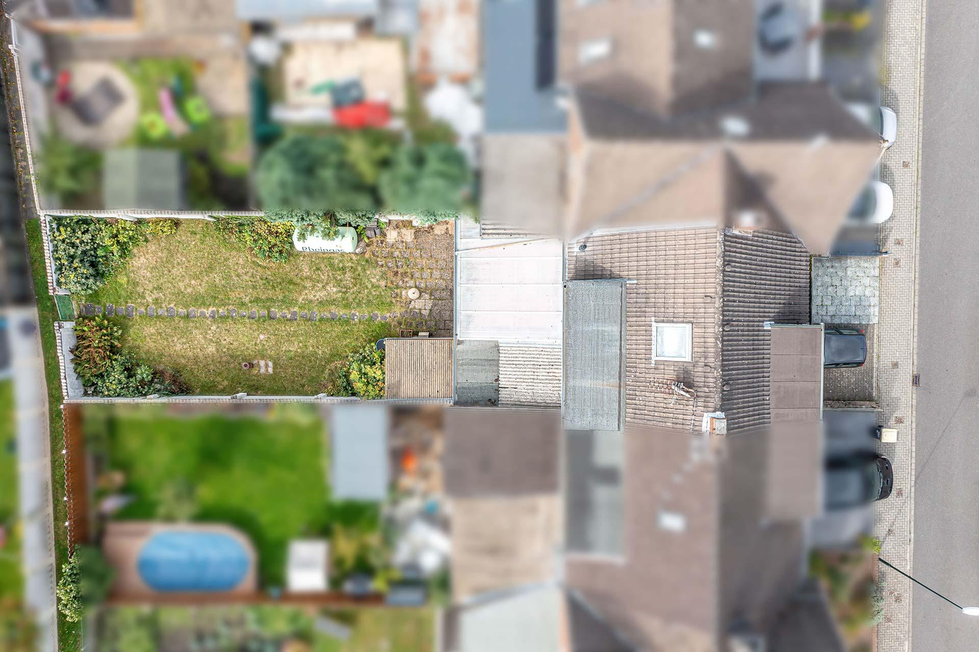 Die Luftaufnahme zeigt das Haus und den Garten sowie den Stellplatz vor dem Haus und Wirtschaftsweg hinter der Mauer am Ende des Grundstücks. Reihenmittelhaus Kerpen