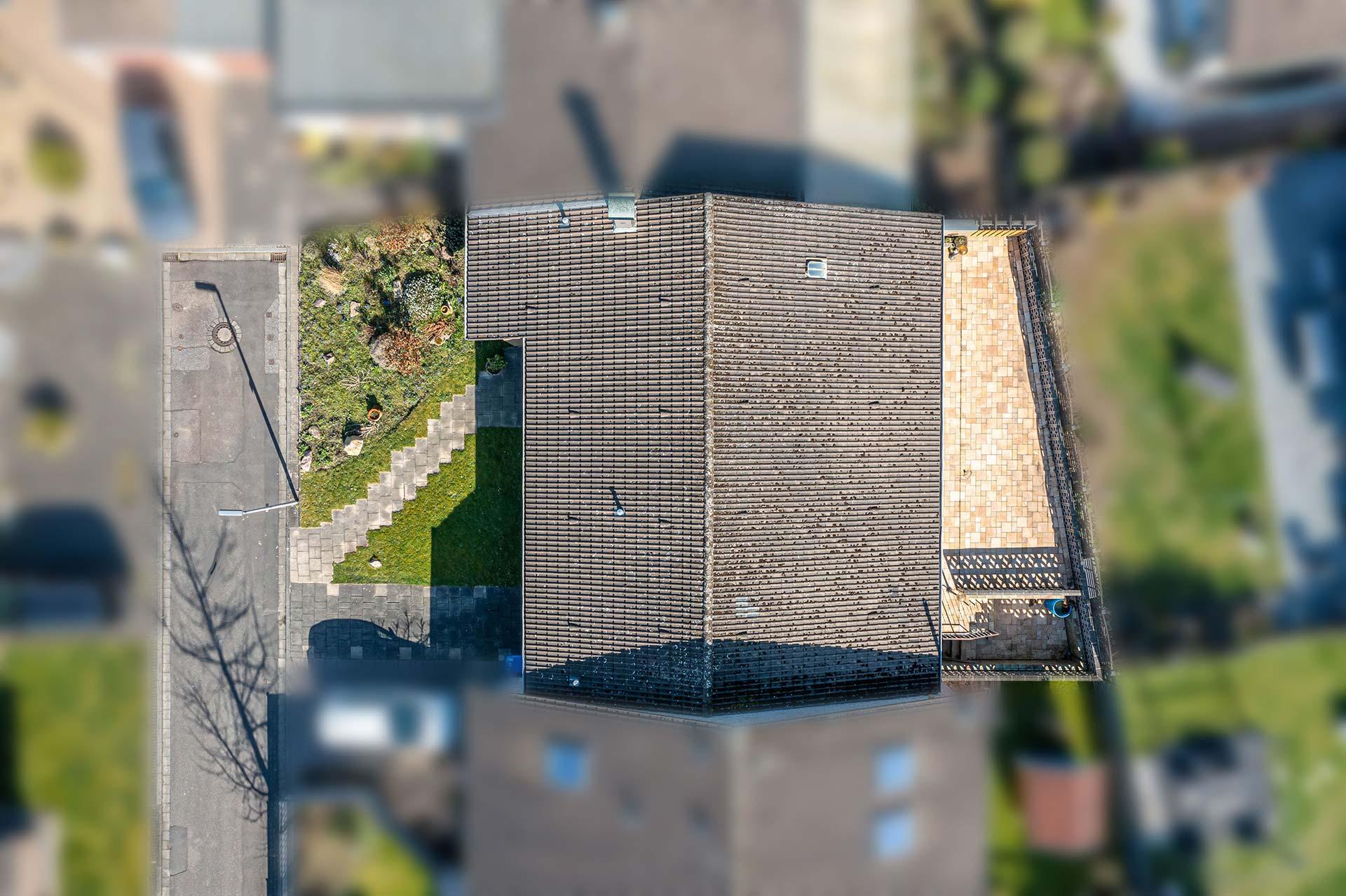 Der Blick von oben zeigt den grünen Vorgarten und den als Terrasse genutzen hinteren Grundstücksbereich. Bungalow Bergheim