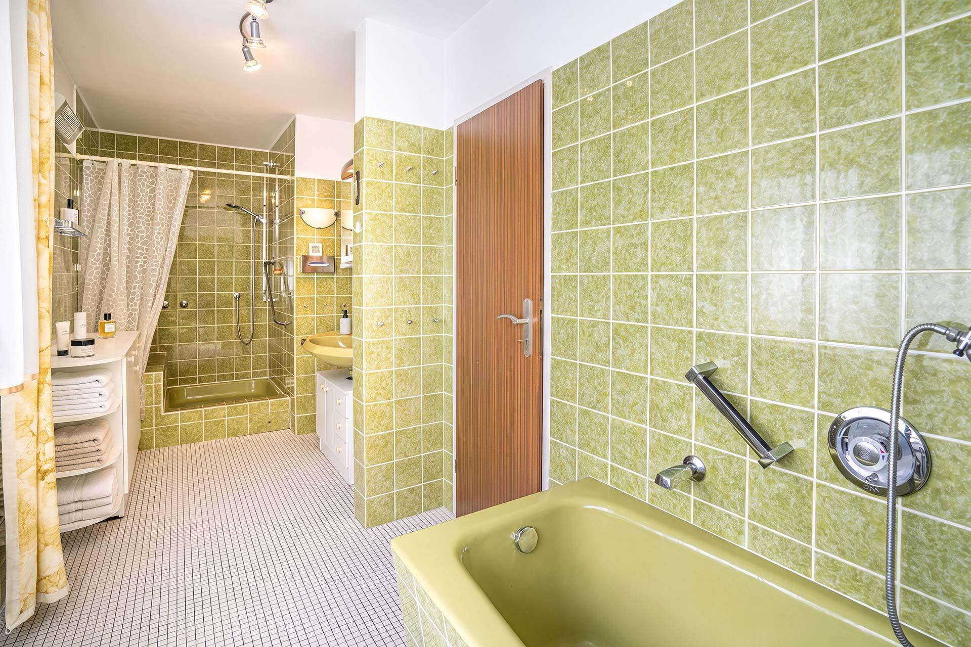 Das Badezimmer ist mit einem Fenster, einer Badewanne, einer Dusche, einem Stand-WC und einem Handwaschbecken ausgestattet. Doppelhaushälfte Bergheim