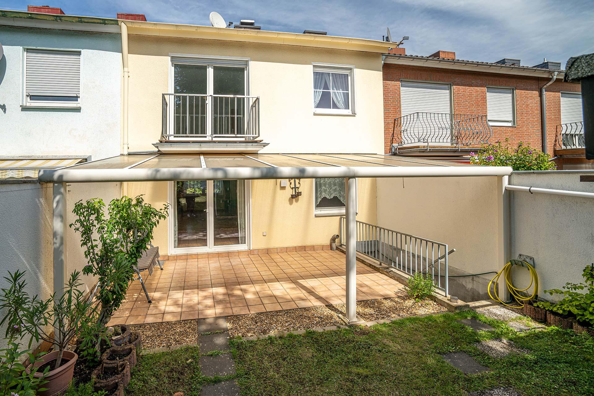 Rückansicht der Immobilie mit überdachter Terrasse, Balkon und Kelleraußentreppe. Reihenmittelhaus Erftstadt
