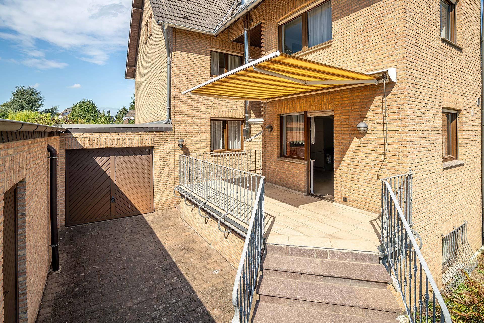 Die Terrasse mit Markiese und der Zugang zur Garage durch ein Extra Garagentor, welches zur Gartenseite eingebaut ist. Doppelhaushälfte Bergheim