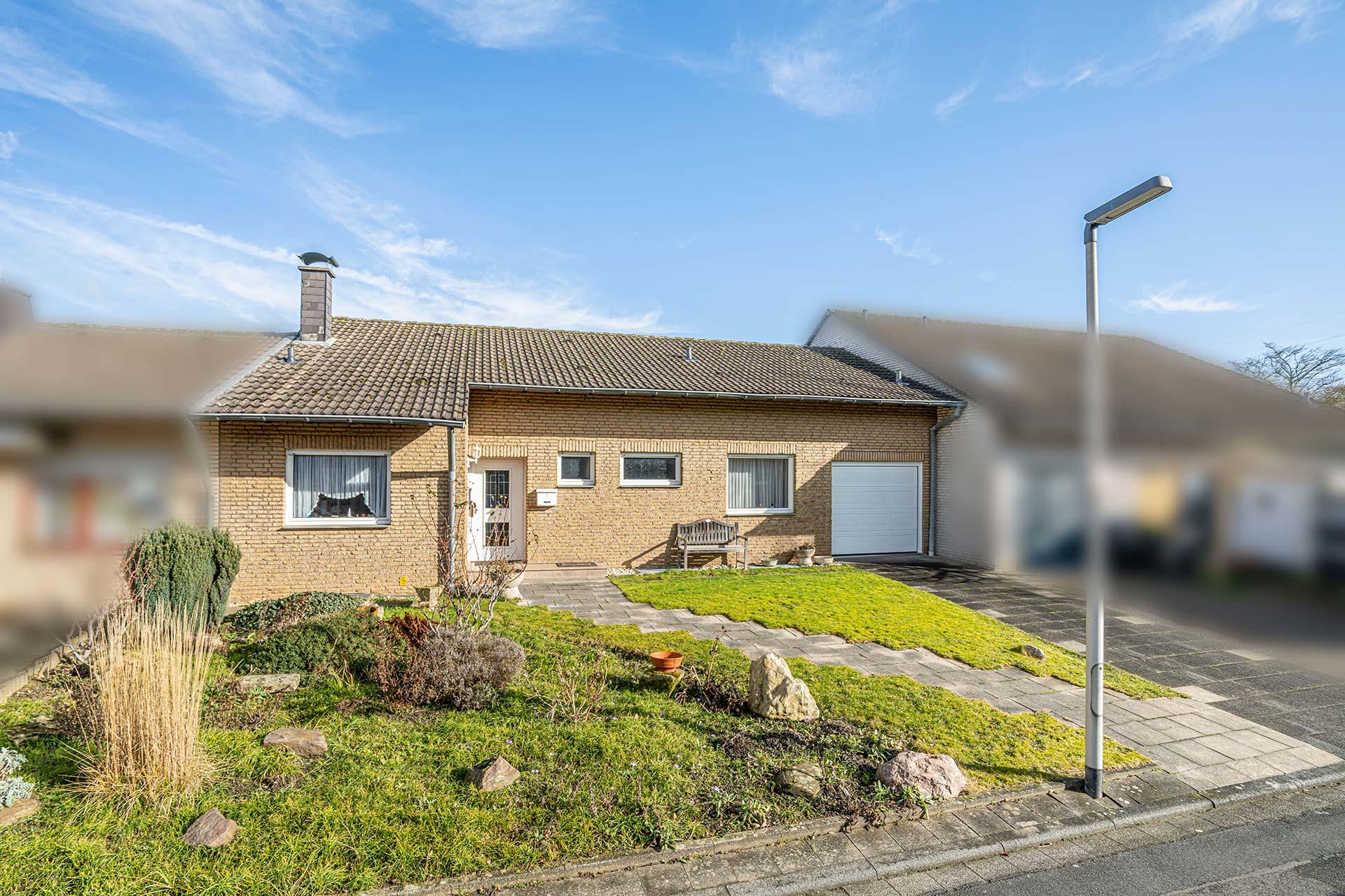 Vorderansicht des Bungalows mit Blick auf die Immobilie und den grünen Vorgarten.  Bungalow Bergheim