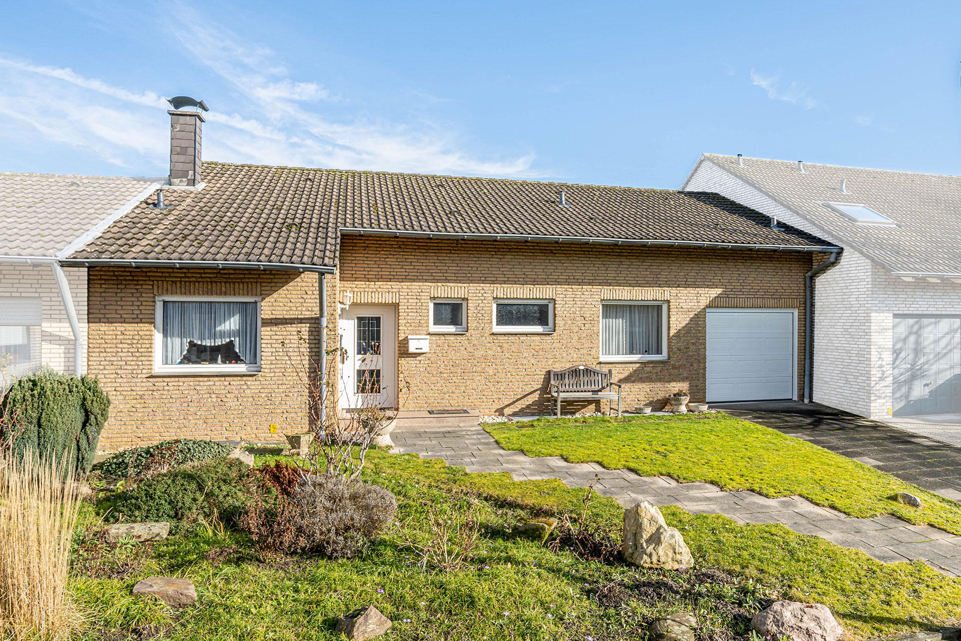 Vorderansicht des Bungalows mit der Zuwegung zur Haustür und der Garage durch den großen Vorgarten Bungalow Bergheim