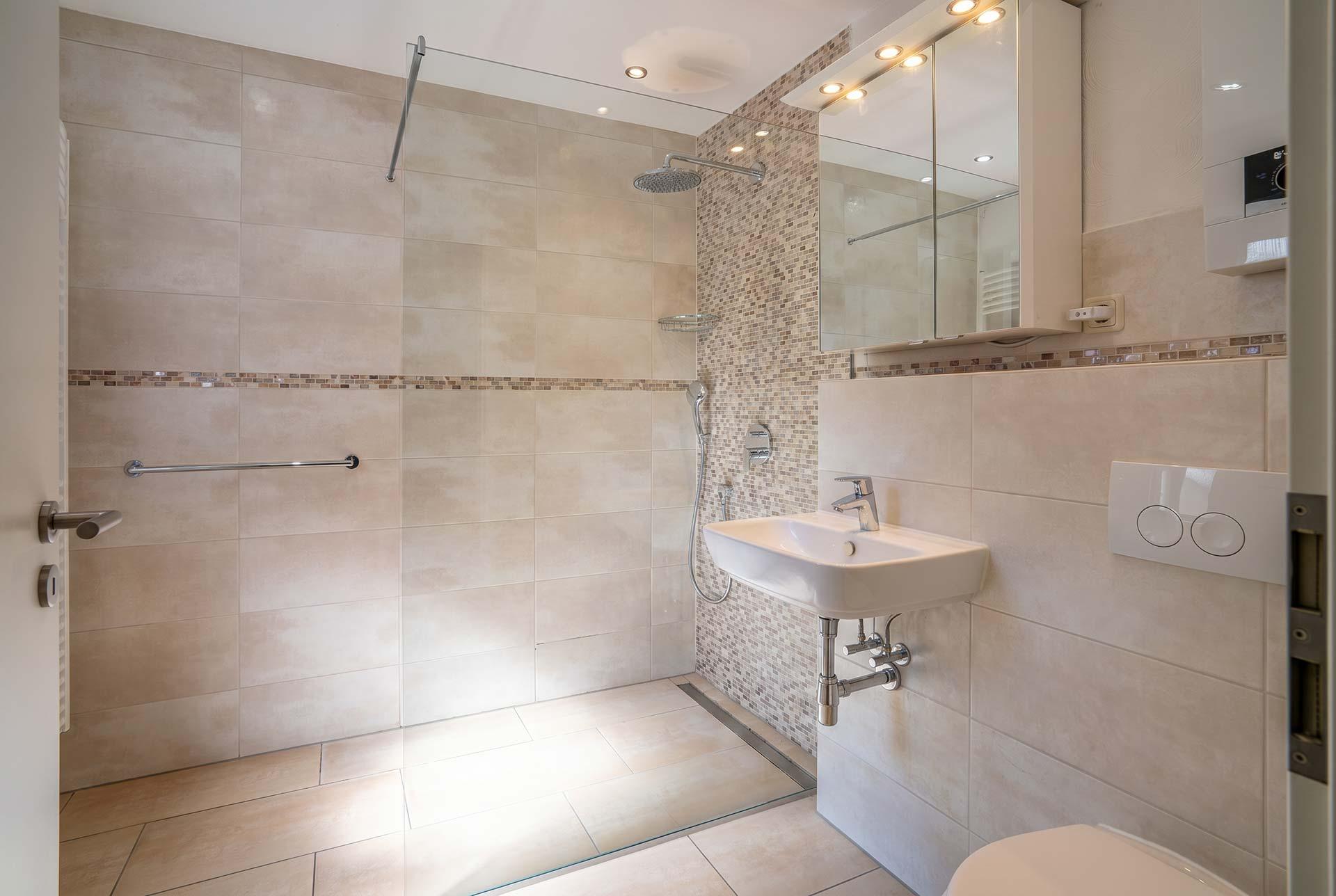 Das Duschbad in Wohnung #1 ist modernisiert und mit einer bodengleichen Dusche, wandhängenden WC und Waschbecken. Immobilie Bedburg