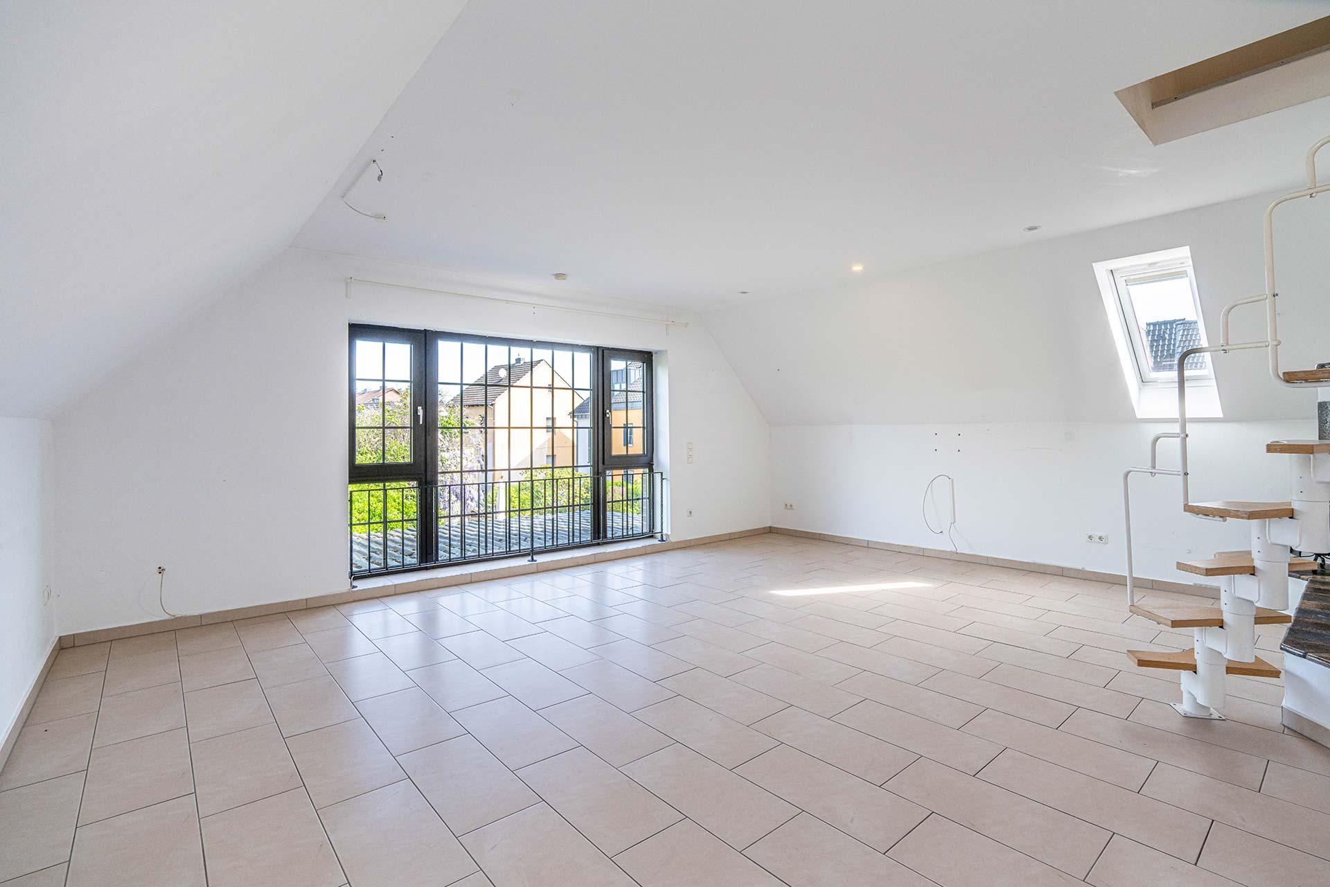 Das große Wohn-/Esszimmer im Dachgeschoss mit großer Sprossenfensterfront. Immobilie Bedburg