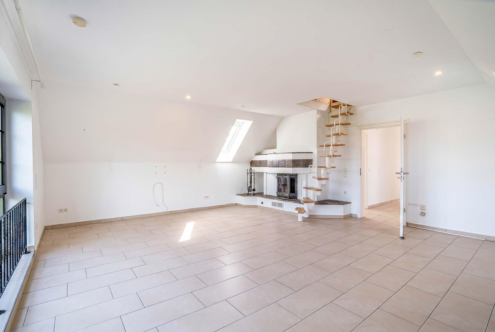 Das Wohn-/Esszimmer mit offenenm Kamin und Treppe in den Spitzboden. Immobilie Bedburg